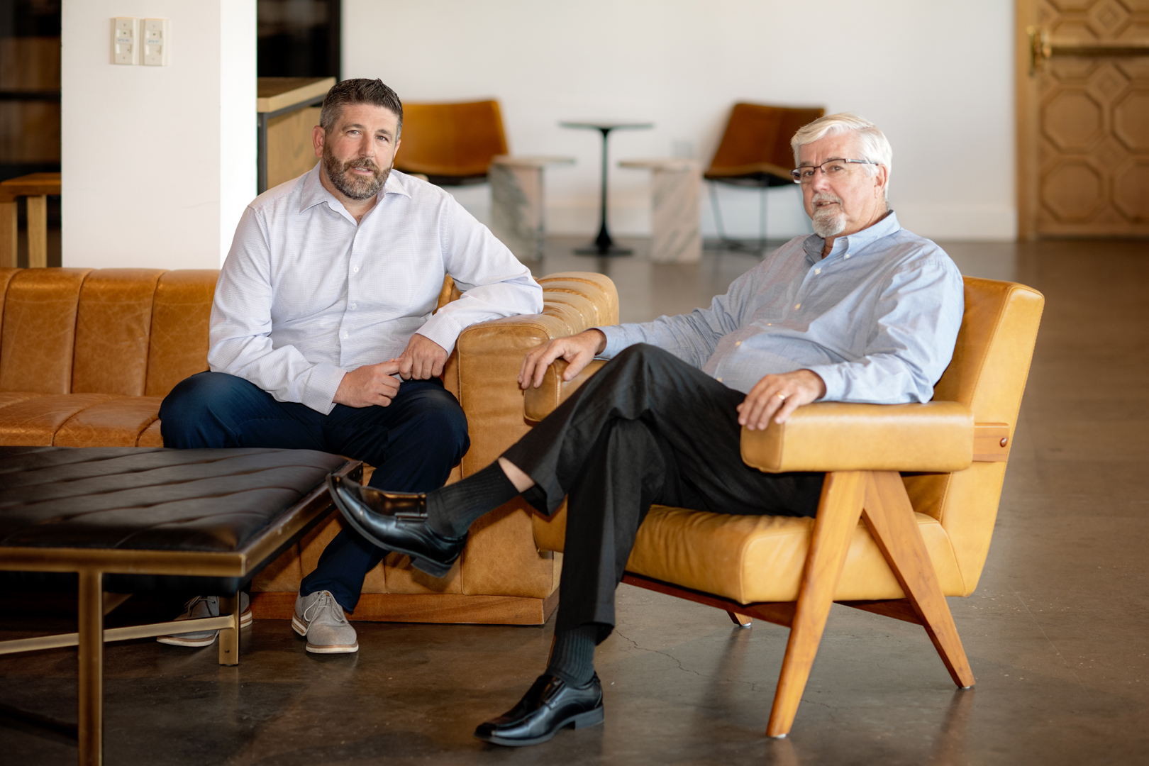 Two men sitting on chairsAI-generated content may be incorrect.